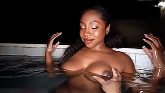 Belleza negra se folla las tetas junto a la piscina